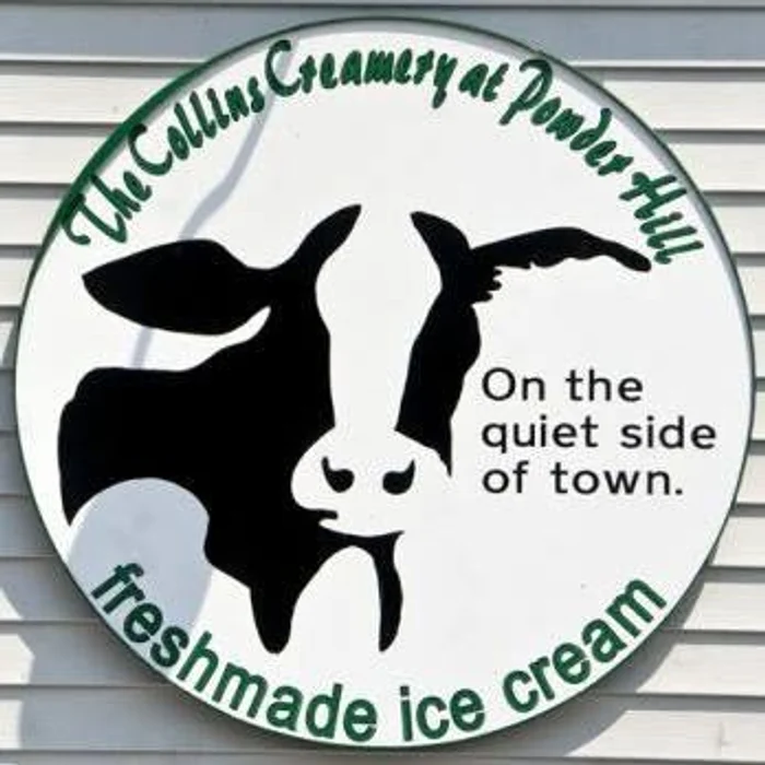 The round Collins Creamery cow sign